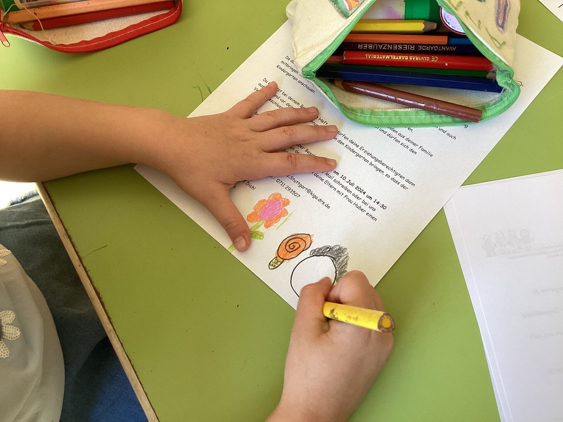 Eine Kinderhand malt ein Gesicht auf ein Blatt Papier im Kinder- und Familienzentrum St. Fidelis im Stuttgarter Westen. 